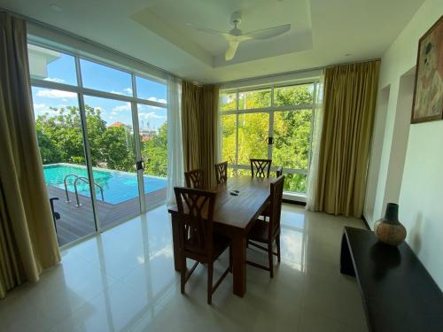 a dining room with a table and a view of a pool at Seaview Prima Villa Karon beach in Karon Beach