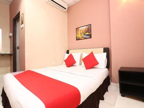 1 dormitorio con 1 cama grande con almohadas rojas en Destiny Riverside Hotel, en Kota Bharu
