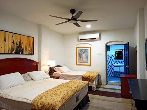 een slaapkamer met 2 bedden en een plafondventilator bij ARAU HERITAGE INN in Arau