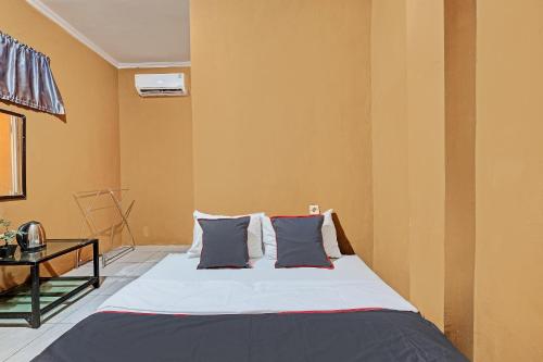 ein Schlafzimmer mit einem Bett mit zwei Kissen in der Unterkunft Collection O 92864 Mitra Residence in Semarang