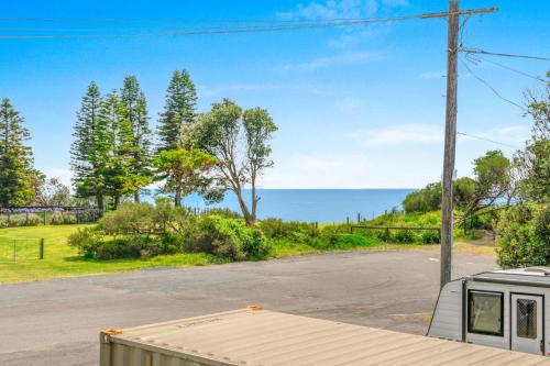 an empty road with a view of the ocean at Sea La Vie - Pet Friendly with Fireplace and Swimming Pool & Spa in Culburra Beach