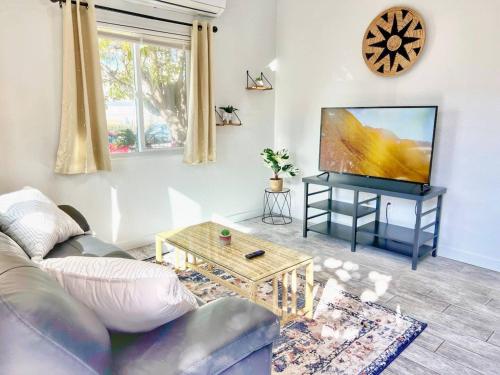 a living room with a couch and a flat screen tv at Charming Flat Near the City in San Diego