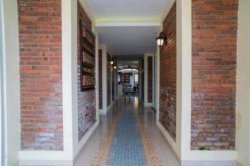 a hallway of a building with a brick wall at Urbanview Hotel Omah Anin Batu by RedDoorz in Tlekung