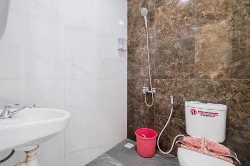 a bathroom with a shower and a toilet and a sink at Urbanview Hotel Omah Anin Batu by RedDoorz in Tlekung