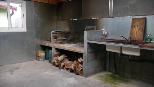 a kitchen with a sink and a pile of wood at L'Idolivier in La Plaine des Palmistes