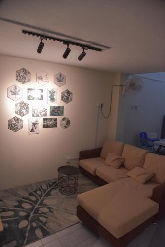 a living room with a couch and pictures on the wall at The Karaoke Homes Ipoh, Oldtown in Ipoh