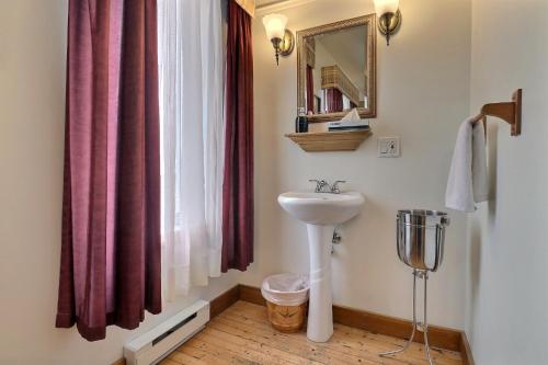 a bathroom with a sink and a window at Auberge de la Vieille Maison in Rimouski