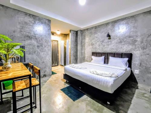 a bedroom with a large bed and a desk at The Loftel Resort in Bangkok