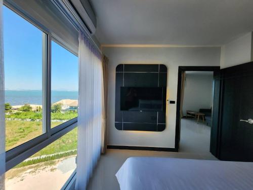 a bedroom with a bed and a large window at LHC HOTEL AND RESORT in Pattaya Central