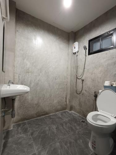 a bathroom with a shower and a toilet and a sink at The Loftel Resort in Bangkok