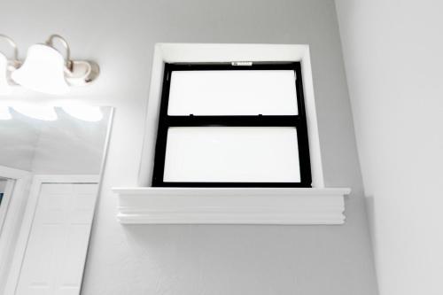 a window in a room with a white wall at The Nesting Gem in Orangetree