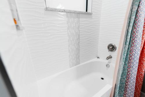 a bathroom with a bath tub with a shower curtain at The Nesting Gem in Orangetree