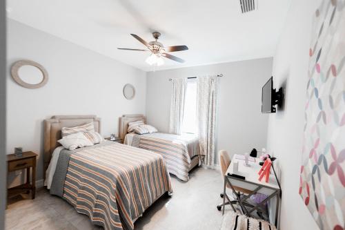 1 dormitorio con 2 camas y ventilador de techo en The Nesting Gem, en Orangetree
