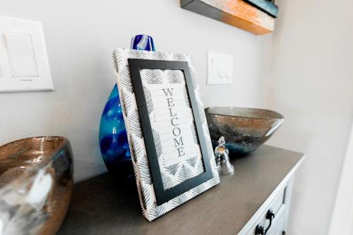 a picture frame on a table with bowls on it at The Nesting Gem in Orangetree