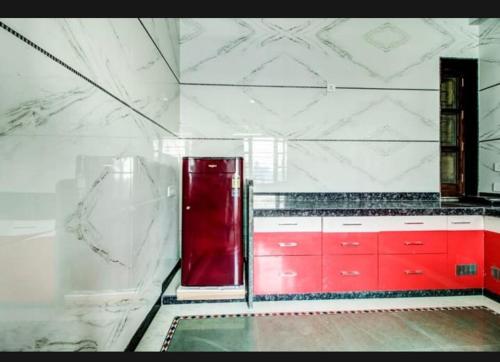 Il comprend une cuisine équipée de placards rouges et d'un réfrigérateur rouge. dans l'établissement 7horses holidays homes, à Udaipur