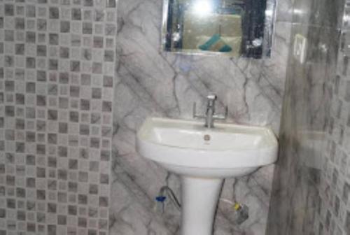 uma casa de banho com um lavatório e uma parede em mármore em Hotel Prince B Guwahati em Guwahati