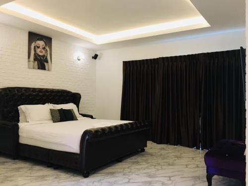 een slaapkamer met een zwart bed en een zwart gordijn bij เดอะวิลล่า71 รีสอร์ท in Ban Zong Katiam