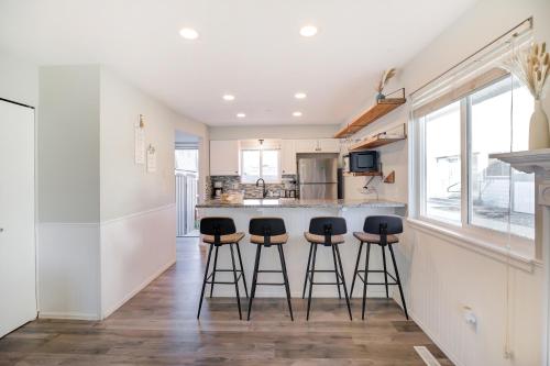 a kitchen with a counter and bar stools at Cozy 2BR Townhome - 1 and a Half Bath - Sleeps 5 - Walk to Old Town Arvada in Arvada