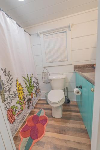 ein Badezimmer mit Toilette und Duschvorhang in der Unterkunft Sophie Cabin National Forest Tiny Cabin in Chattanooga