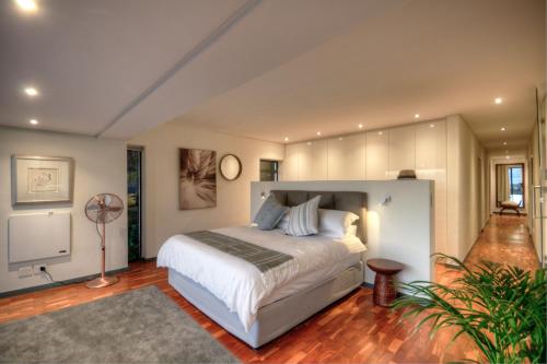 a bedroom with a large bed and a fan at The SunCatcher in Cape Town