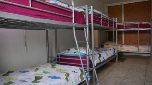 a room with three bunk beds in a room at L'Idolivier in La Plaine des Palmistes