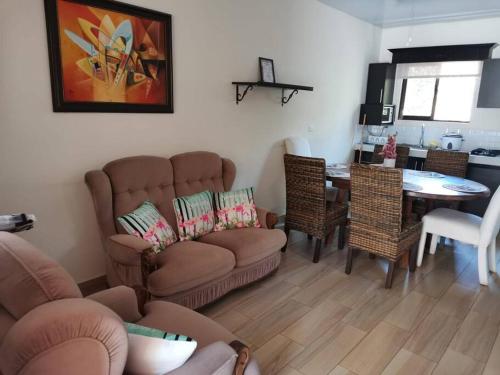 sala de estar con sofá y comedor en VILLA FAMILIAR Oasis Guacalillo, en Tarcoles