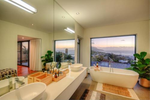 a bathroom with two sinks and a large window at The SunCatcher in Cape Town