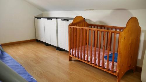 a crib in a bedroom next to a bed at L'Idolivier in La Plaine des Palmistes