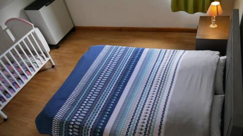 a bed in a room with a crib and a table at L'Idolivier in La Plaine des Palmistes