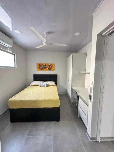 a bedroom with a bed and a desk at CASA MARIPOSA en Punta Leona a 500 metros de la playa FULL EQUIPADA Espacio y precio a tu medida Posibilidad de alquilar la casa entera, los dos apartamentos abajo o los 2 cuartos con baños privados en la planta alta Para 1 a 22 personas in Herradura