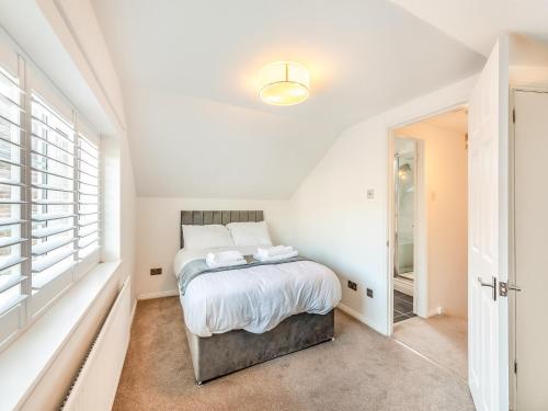 a white bedroom with a bed and a window at Rose Cottage - Uk45971 in Yarm