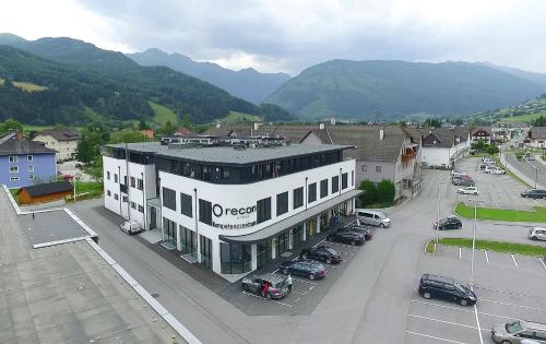a large white building with cars parked in a parking lot at Lungau Living Appartements - Penthouse in Sankt Michael im Lungau