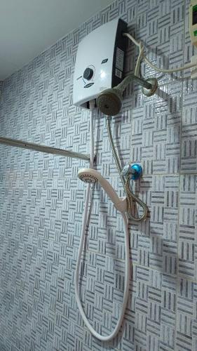 a shower head on a wall in a bathroom at Masterpiece Staycation Makati in Manila