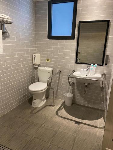 a bathroom with a toilet and a sink at Bulowan Hotel in Hualien City