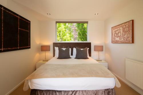 - une chambre avec un grand lit et une fenêtre dans l'établissement Amaroo, à Queenstown