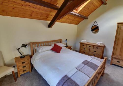 a bedroom with a large bed and a chair at Y Stabl in Llandinam