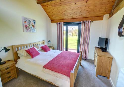 a bedroom with a large bed and a television at Corlan in Llandinam