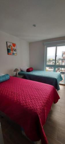 two beds in a room with a window at Lindo Apartamento en Parque Mateo in Guatemala