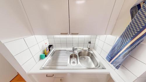 eine kleine Küche mit einem Waschbecken in der Ecke in der Unterkunft Charmante zentrale 2.5 Zimmer Maisonette Wohnung in Chur