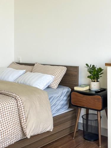 a bedroom with a bed and a nightstand with a plant at Nai Homestay 2 in Da Thanh