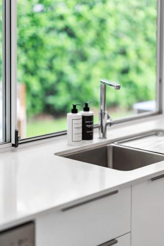 a kitchen counter with a sink and a window at Hamptons by Khove in Gold Coast