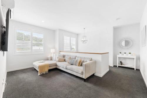 a white living room with a couch and a table at Hamptons by Khove in Gold Coast