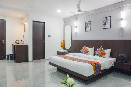 a bedroom with a large bed and a mirror at FabHotel Prime Stay Inn in Pune