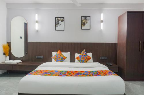 a bedroom with a large bed and a mirror at FabHotel Prime Stay Inn in Pune