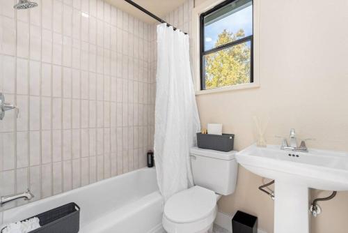 a white bathroom with a toilet and a sink at Downtown Lodi l Renovated l 5 Bedrooms l Sleeps 10 in Lodi