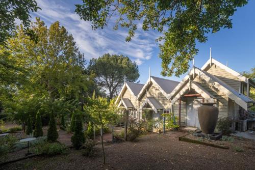 a house with a garden in front of it at Velvet Pear Cottage in Central Tilba