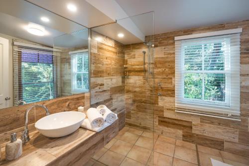 a bathroom with a sink and a shower at Velvet Pear Cottage in Central Tilba