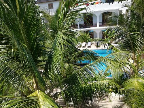 an aerial view of a hotel with palm trees and a swimming pool at The New Blue Waves Hotel in Jambiani