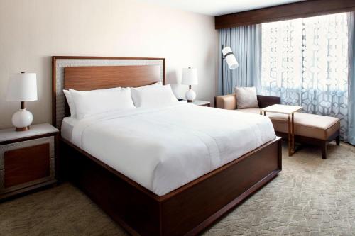 a bedroom with a large white bed and a chair at Raleigh Marriott Crabtree Valley in Raleigh