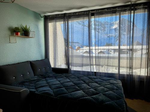 a bedroom with a bed in front of a window at Plein centre station vue imprenable in La Mongie